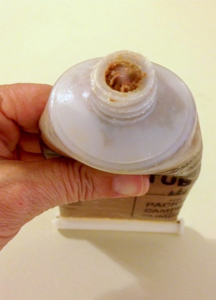 A closeup of the mouth of a food tube with canned pet food inside