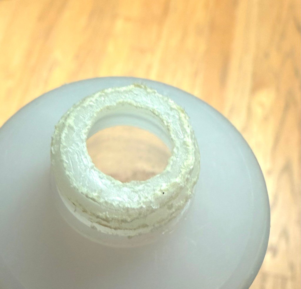 A closeup of the threaded end of a food tube that shows many bite marks from dogs